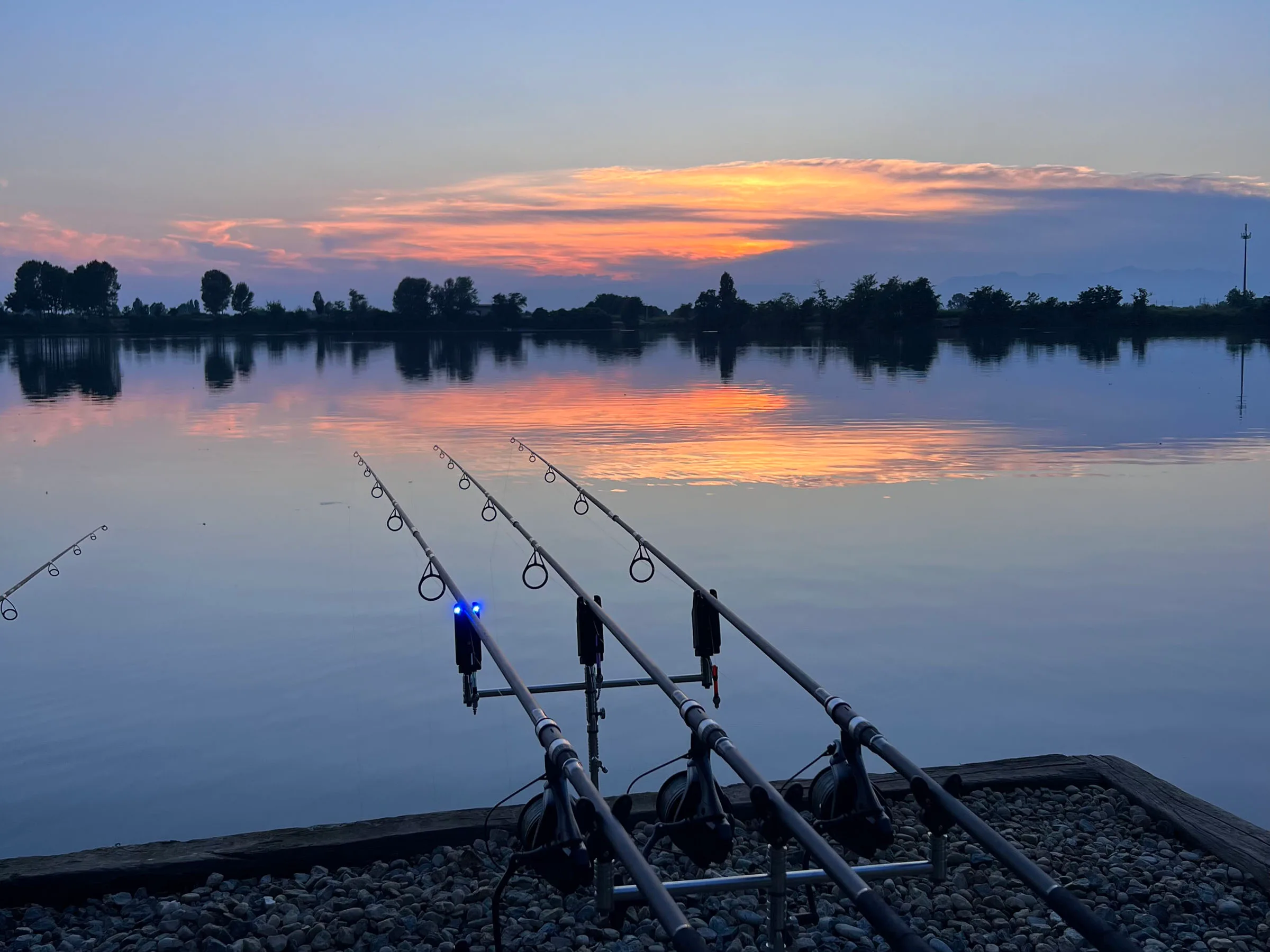 Fishing rods by lake at sunset